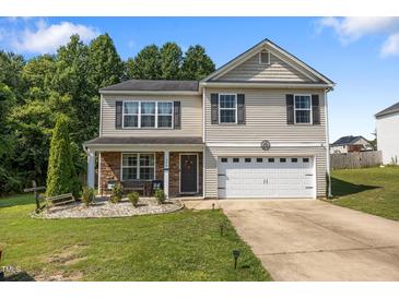 Charming two-story home with a well-manicured lawn, covered front porch, and two-car garage, perfect for suburban living at 206 Vandercroft Way, Bunnlevel, NC 28323
