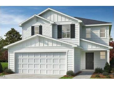 Charming two-story home featuring a two-car garage and inviting curb appeal with lush landscaping at 236 Norman Ave, Lillington, NC 27546