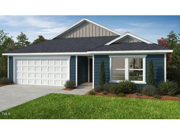 Charming single-story home with a two-car garage, blue siding, and a well-manicured lawn at 246 Norman Ave, Lillington, NC 27546
