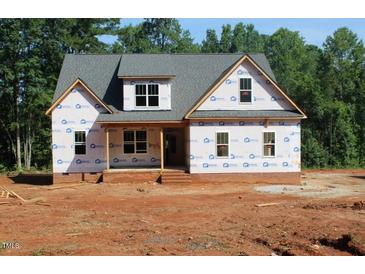 Two-story home with a charming covered porch and a mix of brick and siding exterior at 25 Autumnwood Ln, Spring Hope, NC 27882