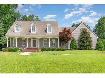 Charming home featuring a welcoming front porch with classic columns and a beautifully landscaped front yard at 2945 Chimney Hill Trl, Rocky Mount, NC 27804