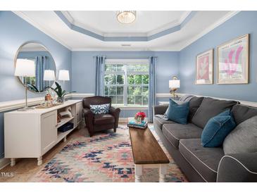 Comfortable living room with blue accent wall, natural light, and stylish furnishings at 413 Braxman Ln, Holly Springs, NC 27540