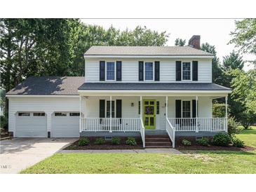 Charming two-story home with a welcoming front porch, bright yellow door, and well-manicured lawn at 505 Commander Dr, Wendell, NC 27591