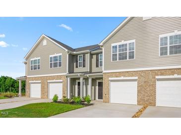 Charming townhome exterior showing garage and neutral siding and brick at 5560 Henley Ridge Dr # 187, Graham, NC 27253