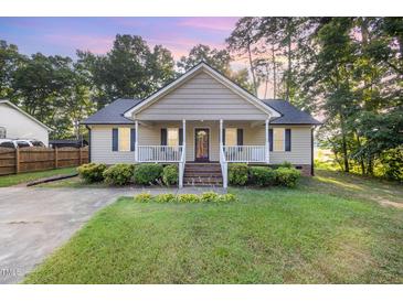 Charming home featuring a covered front porch, manicured lawn, and inviting curb appeal at 609 N Country Club Dr, Oxford, NC 27565