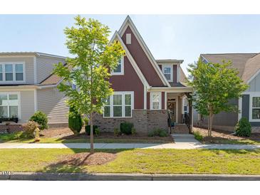 Charming two-story home with brick accents, manicured lawn, and mature landscaping at 6612 Enrichment Ln, Raleigh, NC 27616