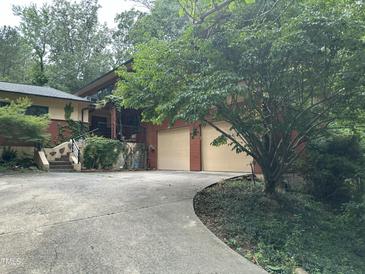 Beautiful home featuring a two-car garage, lush landscaping, and a charming stone staircase at 71010 Russell, Chapel Hill, NC 27517