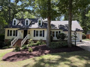 Charming home with dormer windows, black shutters, landscaped yard, and brick walkway at 8629 Windjammer Dr, Raleigh, NC 27615