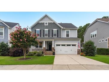 Beautiful two-story home with gray siding, stone accents, a covered porch, and a well-manicured front yard and 2-car garage at 908 Woodland Grove Way, Wake Forest, NC 27587