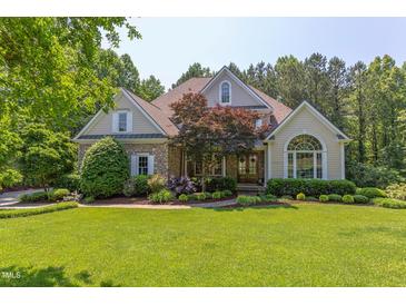 Charming home featuring stone accents, manicured lawn, and mature trees for enhanced curb appeal at 102 Bosswood Ct, Cary, NC 27518