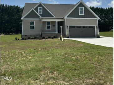 Charming two-story home featuring a covered porch, two-car garage, and neutral exterior at 106 Viola Ln, Franklinton, NC 27525