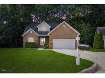 Charming brick home with a well-manicured lawn and two-car garage, perfect curb appeal at 1209 Waterford Green Dr Dr, Apex, NC 27502