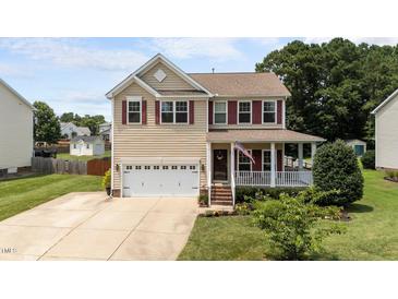 Charming two-story home with a front porch, a well-manicured lawn and a two car garage at 1713 Mclaurin Ln, Fuquay Varina, NC 27526