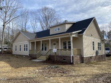 Inviting ranch-style home features a covered front porch with wooden columns and a brick foundation at 206 E Silver Belle Dr, Zebulon, NC 27597