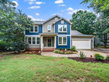 Charming two-story home with a lush green lawn and mature landscaping at 218 Inwood Forest Dr, Raleigh, NC 27603