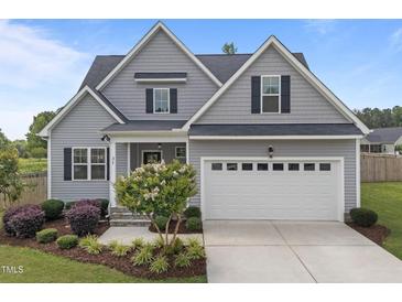Charming gray two-story home with a two-car garage, landscaped yard, and inviting front entrance at 31 Sweet Birch Ave, Zebulon, NC 27597