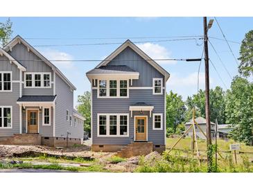 Charming two-story home with gray siding, white trim, and a welcoming front porch at 317 W Murray Ave, Durham, NC 27704