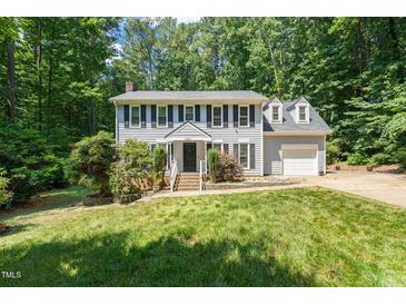 Traditional two-story home boasts a manicured lawn and classic architectural details at 3821 Whispering Branch Rd, Raleigh, NC 27613