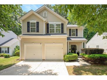 Charming two-story home boasts a two-car garage and classic curb appeal with lush landscaping and a welcoming entrance at 4524 Drewbridge Way, Raleigh, NC 27604