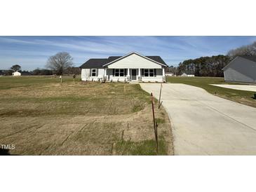 Inviting single-story home with a modern design and a spacious front yard at 57 Faucette Dr, Selma, NC 27576