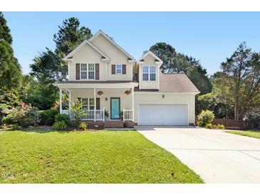 Charming two-story home boasts a welcoming porch, a well-manicured lawn, and an attached two car garage at 9416 Buggy Run Cir, Wake Forest, NC 27587