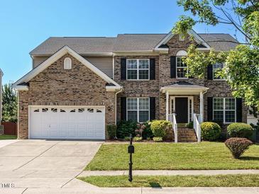 Charming two-story brick home with a well-manicured lawn and a two-car garage at 1035 Evening Shade Ave, Rolesville, NC 27571