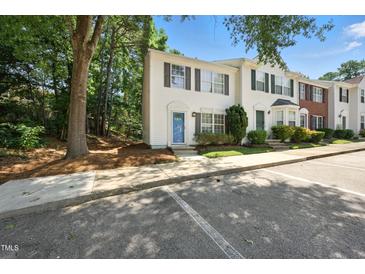 Charming townhouse with blue door, shuttered windows, and well-maintained landscaping near ample parking at 110 Virens Dr, Cary, NC 27511