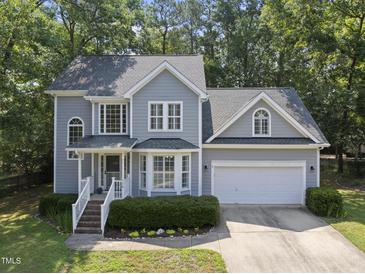 Charming two-story home with attached garage, manicured landscaping, and mature trees at 116 Hidden Cellars Dr, Holly Springs, NC 27540