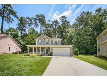 Charming two-story home with a well-maintained lawn, inviting front porch, and a two-car garage at 1909 Piperwood Ct, Durham, NC 27713