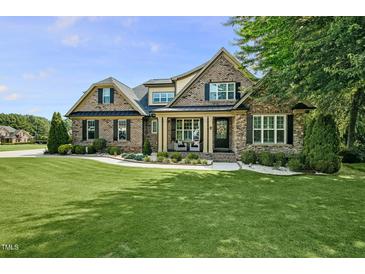 Beautiful brick home with lush lawn and well-manicured landscaping, offering great curb appeal at 39 Wood Stork Ct, Clayton, NC 27520