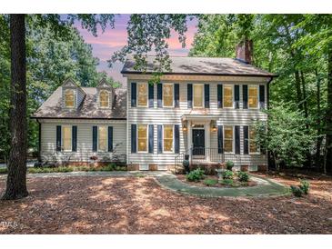 Charming two-story home with black shutters, a brick chimney, and mature landscaping at 5113 Linksland Dr, Holly Springs, NC 27540