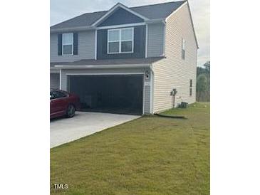 Charming two-story home with attached garage and well-manicured lawn at 512 Crow Field St, Roxboro, NC 27574