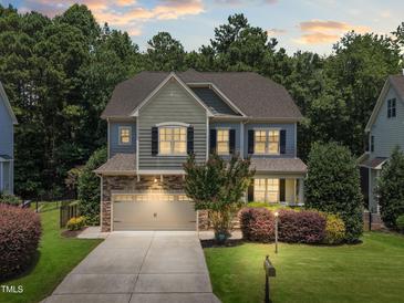 Beautiful two-story home with a stone and siding exterior, attached garage, and professionally landscaped yard at 529 Lake Gaston Dr, Fuquay Varina, NC 27526