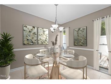 Bright dining room features a modern chandelier, a glass table set for four, and neutral wall decor at 7159 Sandy Creek Dr, Raleigh, NC 27615