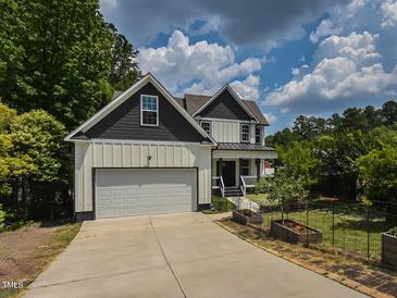 Charming two-story home featuring white siding, a gray roof, an attached two-car garage, and a well-maintained front lawn at 723 Lindley Dr, Durham, NC 27703