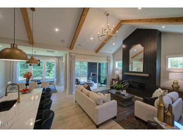Bright living room boasts vaulted ceilings, wooden beams, sleek fireplace, and access to a screened-in porch at 16 Calming Pl Pl, Fuquay Varina, NC 27526