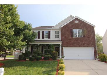 Two-story home with brick and siding, complemented by a well-manicured lawn and vibrant, mature landscaping at 5456 Thunderidge Dr, Raleigh, NC 27610