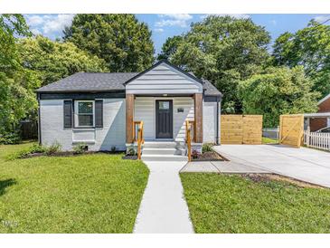 Charming home with white brick, inviting porch, and lush green lawn at 709 Brighton Rd, Raleigh, NC 27610