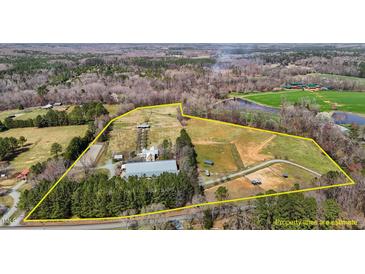 Expansive aerial view of a property with vast land, ponds, riding stables and buildings, highlighted by an estimated boundary line at 756 Epps Clark Rd, Siler City, NC 27344