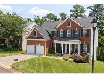 Beautiful two-story brick home with a manicured lawn, two-car garage, and a welcoming front porch at 8106 Sommerwell St, Raleigh, NC 27613