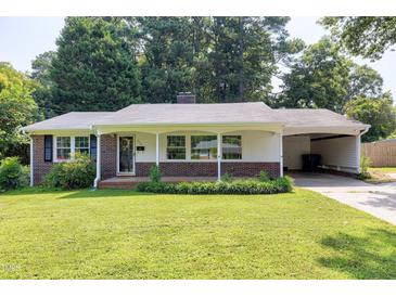 Charming single-story brick home featuring a well-manicured lawn and covered carport on a sunny day at 827 Union St, Cary, NC 27511
