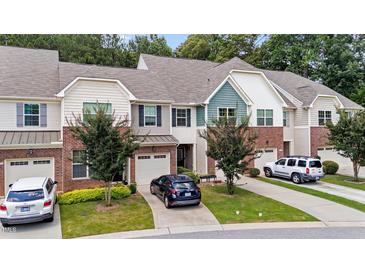 Charming townhome featuring a brick facade, attached garage, and well-maintained landscaping at 927 Contessa Dr, Cary, NC 27513