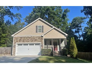 Charming home with a two-car garage, manicured lawn, and a mix of stone and shingle exterior at 120 Glen Oaks Dr, Youngsville, NC 27596
