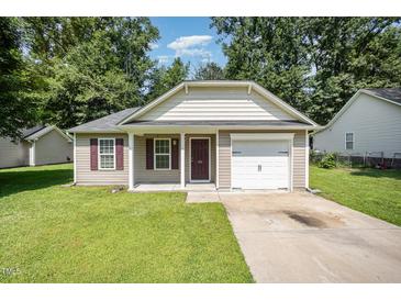 Charming single-story home with a manicured lawn, inviting front porch, and an attached single-car garage at 125 Brook Pl, Smithfield, NC 27577