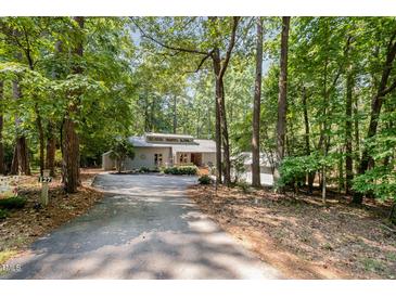 Secluded gray home with a lush, wooded lot and long driveway at 127 Creekwood, Pittsboro, NC 27312