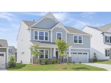 Charming two-story home with gray siding, manicured lawn, and attached two car garage at 130 Summer Mist Ln # 160, Clayton, NC 27527