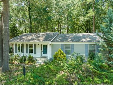 Charming single-story home with gray shutters and a wooded lot, creating a private and serene setting at 1317 Elmset Ln, Durham, NC 27713