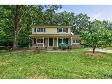 Charming two-story home with a brick and yellow exterior, a covered front porch, and a green lawn at 1704 Little John Ct, Burlington, NC 27217