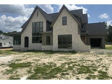 Stunning new construction home boasting a stone facade and black framed windows at 200 Meadow Walk Dr, Fuquay Varina, NC 27526