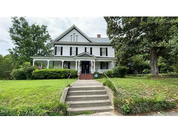 Charming two-story home with a welcoming front porch and well-manicured lawn at 401 N Main St, Louisburg, NC 27549